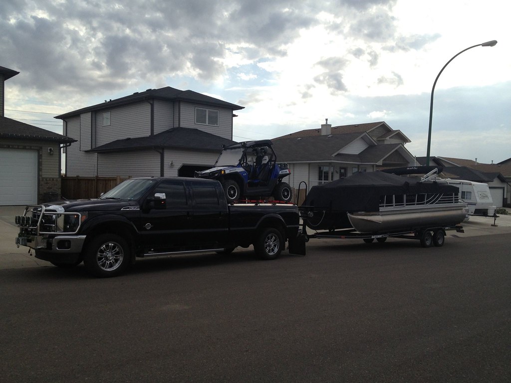 Pickup Truck Towing Boat Trailer and Hauling Side by Side on Heavy-Duty Truck Bed Cover